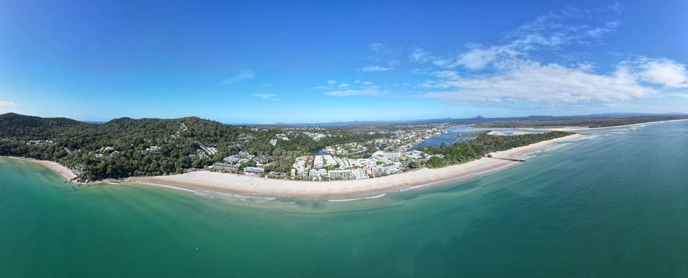 Aerial view of the Sunshine Coast coastline at Noosa Heads, with turquoise water meeting the headland